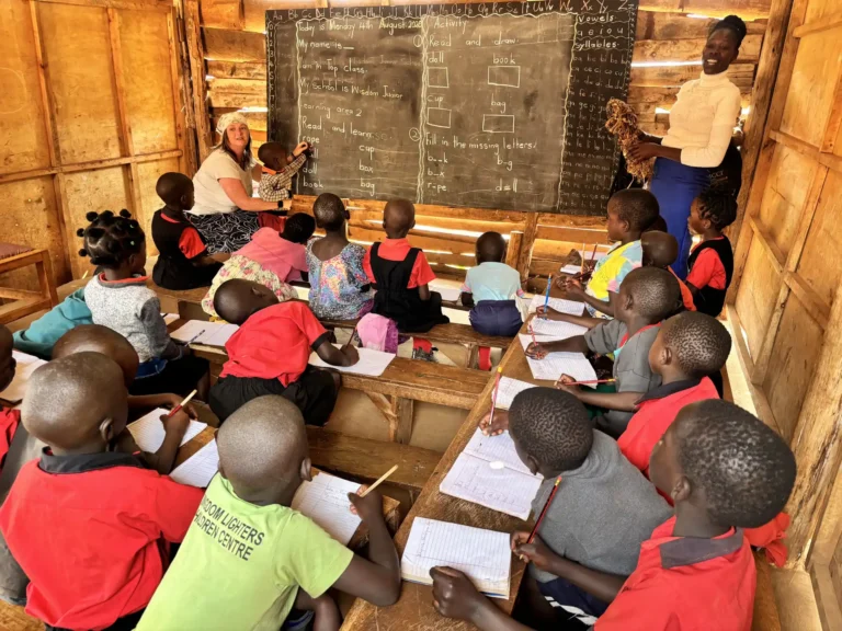 A Ugandan classroom with children looking at the black board